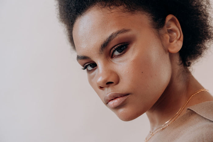 Close-up portrait of a woman with natural curly hair and clear skin