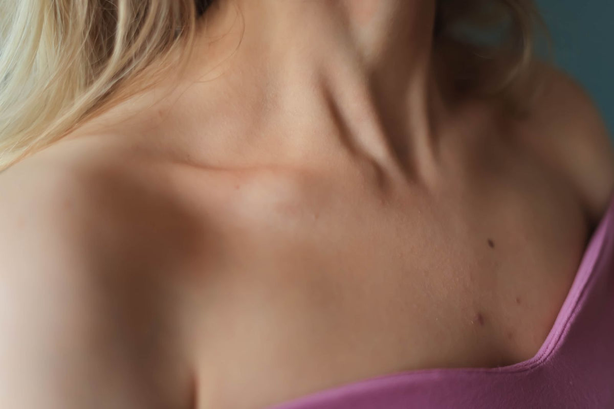 Close-up of a woman's neck and collarbone showing natural skin detail